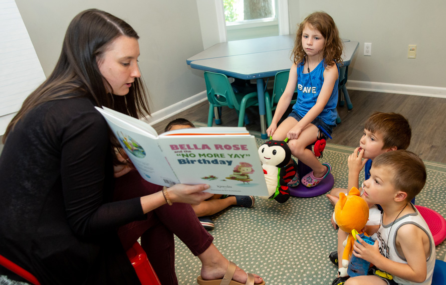 Teacher reading book to group of children