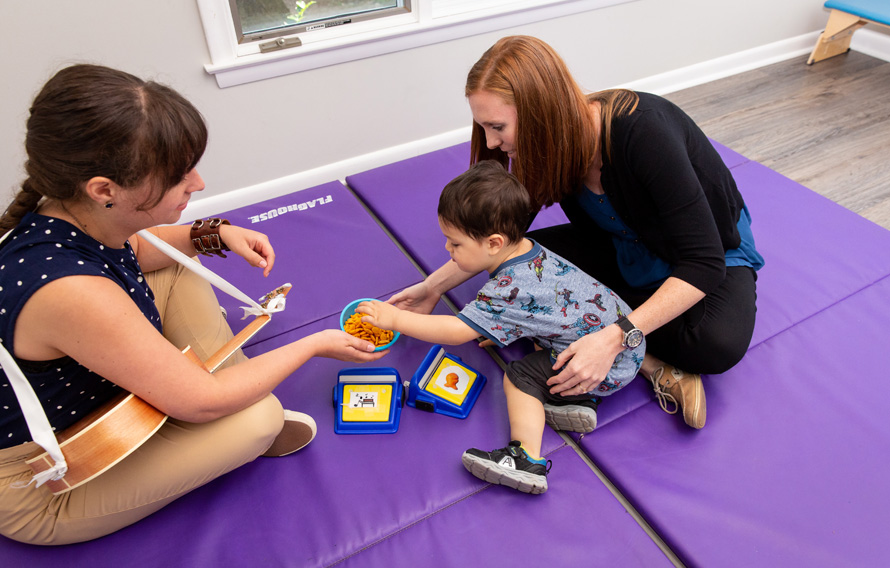 boy with goldfish and 2 therapists