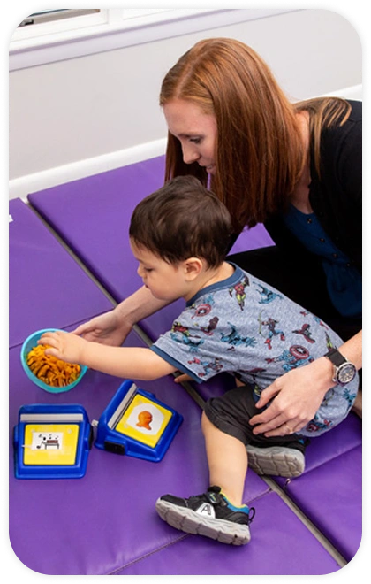 Small boy with teacher on feeding therapy